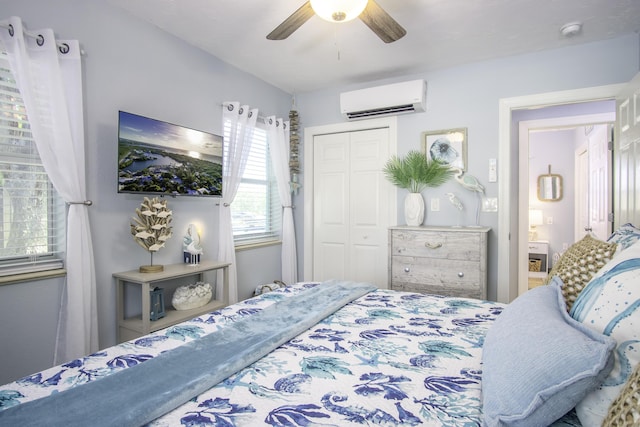 bedroom with a wall mounted air conditioner, ceiling fan, and a closet