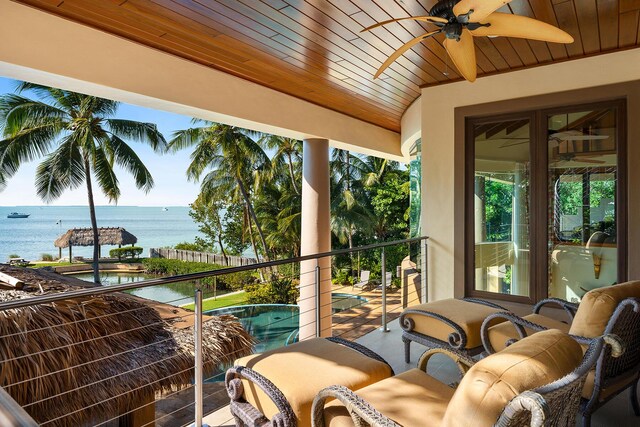 balcony with a water view and ceiling fan