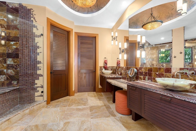 bathroom with vanity, a tile shower, and decorative backsplash