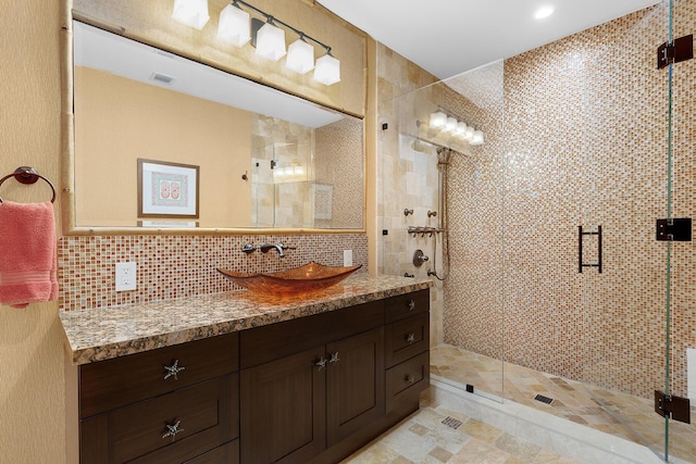 bathroom with tasteful backsplash, vanity, tile walls, and walk in shower