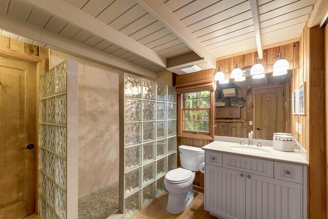 bathroom featuring wooden walls, vanity, beamed ceiling, a shower, and toilet