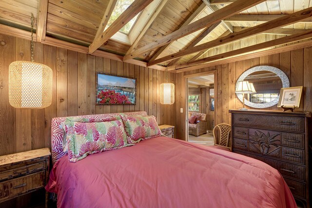 bedroom featuring wooden walls, vaulted ceiling with skylight, and wooden ceiling