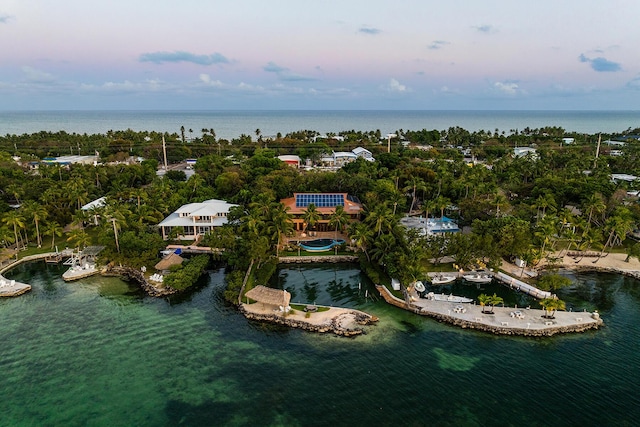 aerial view at dusk featuring a water view