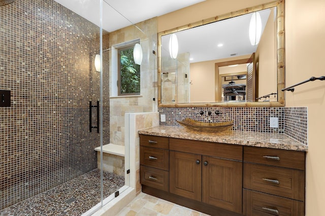 bathroom with an enclosed shower, vanity, tile walls, and backsplash