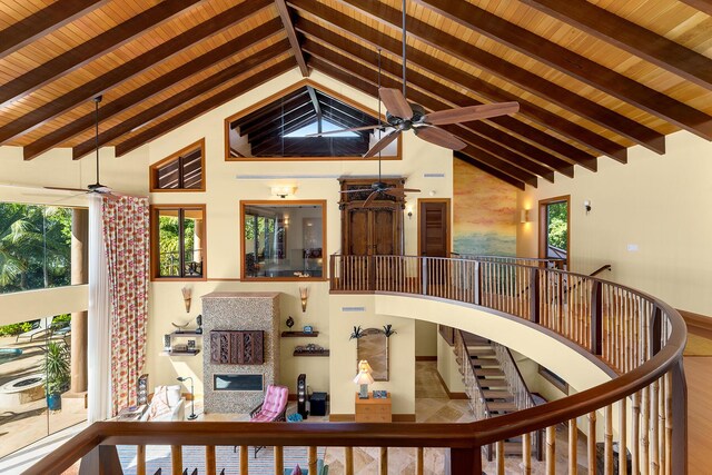 stairway featuring beam ceiling, ceiling fan, and high vaulted ceiling