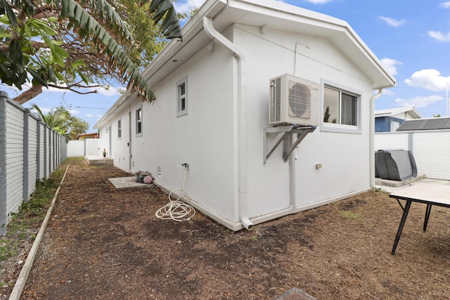 view of property exterior featuring ac unit, a fenced backyard, and stucco siding