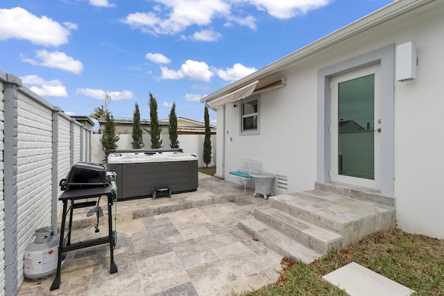 view of patio / terrace featuring a hot tub, grilling area, and a fenced backyard