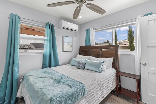 bedroom featuring recessed lighting, ceiling fan, wood finished floors, and a wall mounted AC