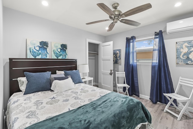 bedroom with recessed lighting, a wall unit AC, light wood-style flooring, and baseboards