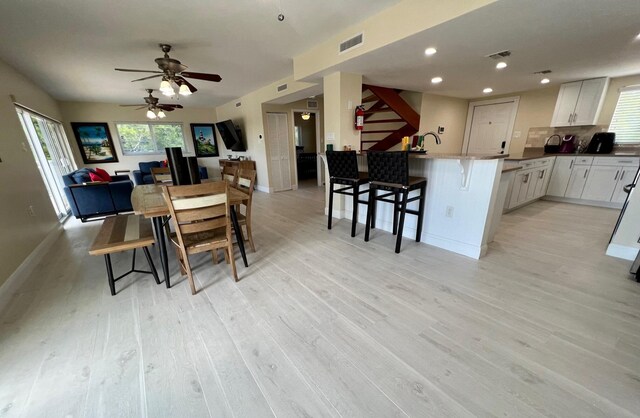 dining room featuring a wealth of natural light, ceiling fan, and light hardwood / wood-style flooring