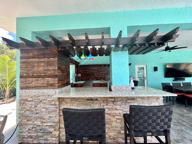 view of patio with an outdoor bar and ceiling fan