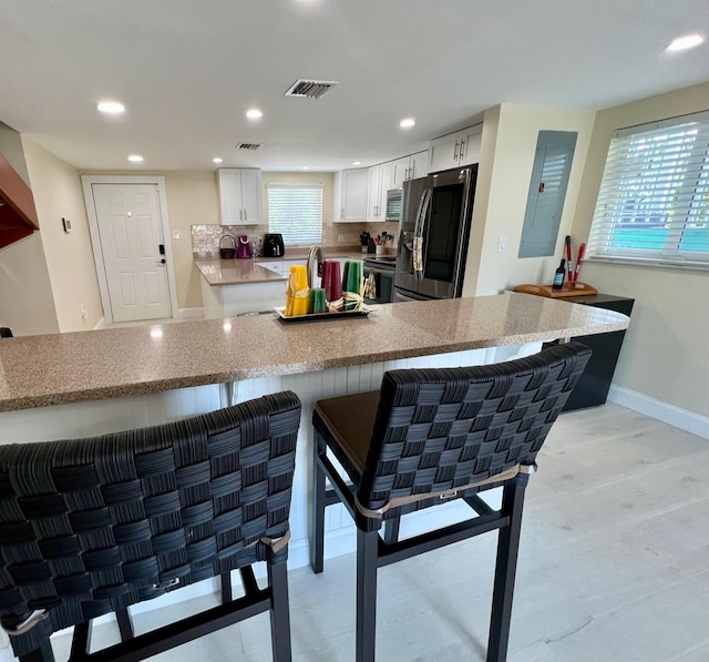 kitchen featuring white cabinetry, appliances with stainless steel finishes, and kitchen peninsula