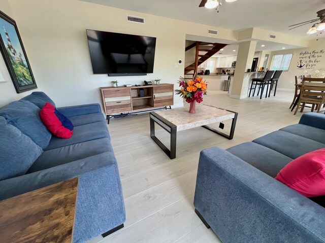 living room with light wood-type flooring and ceiling fan