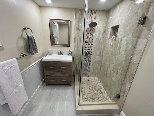 bathroom with wood-type flooring, an enclosed shower, and vanity