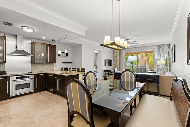 kitchen featuring dark brown cabinetry, a peninsula, stainless steel oven, wall chimney exhaust hood, and crown molding