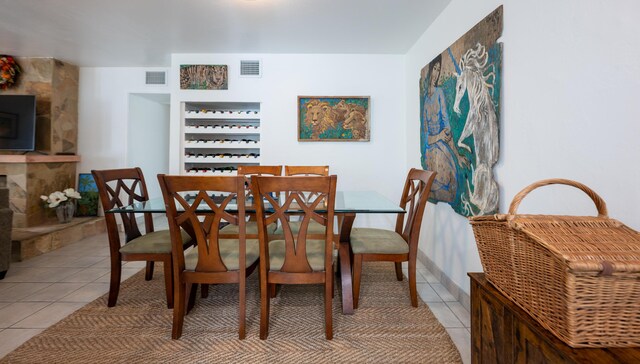 dining space featuring a fireplace and light tile patterned floors