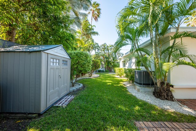 view of yard featuring a storage shed and central AC unit