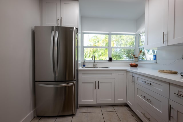 kitchen featuring sink, stainless steel fridge, and white cabinets