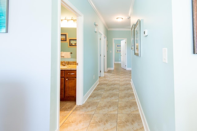 corridor featuring ornamental molding, sink, and light tile patterned floors