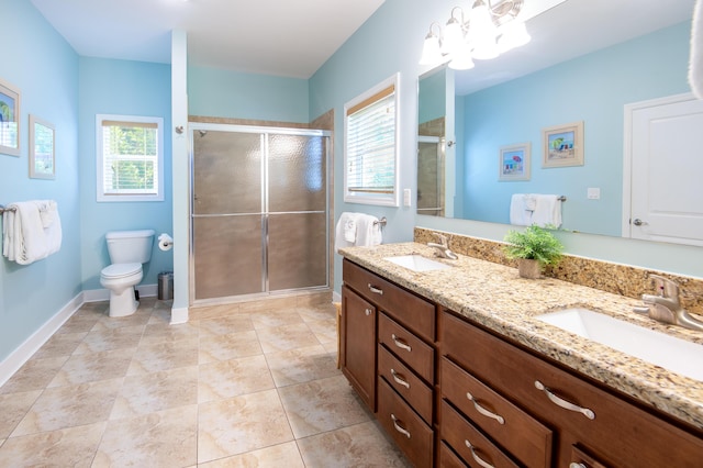 bathroom with vanity, a healthy amount of sunlight, an enclosed shower, and toilet