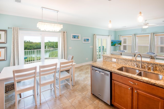 kitchen featuring dishwasher, sink, pendant lighting, and light stone counters