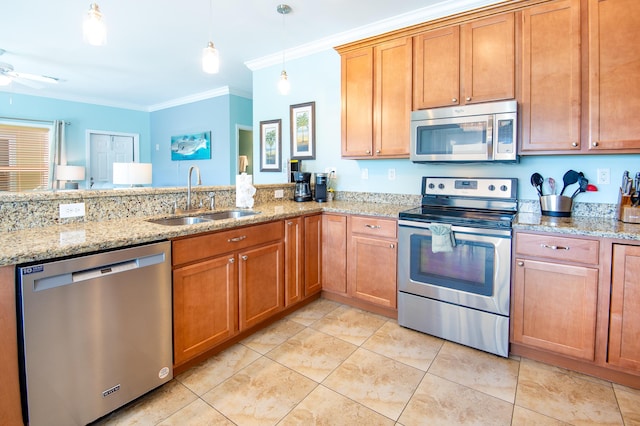 kitchen with sink, crown molding, light stone counters, appliances with stainless steel finishes, and pendant lighting