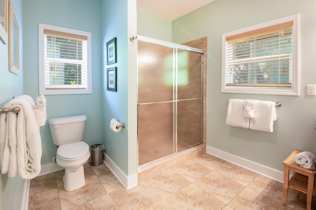 bathroom with a shower with door and toilet