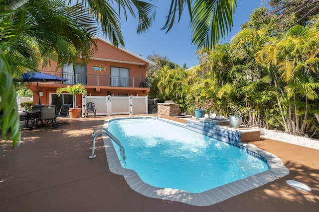 outdoor pool with a patio area and outdoor dining area