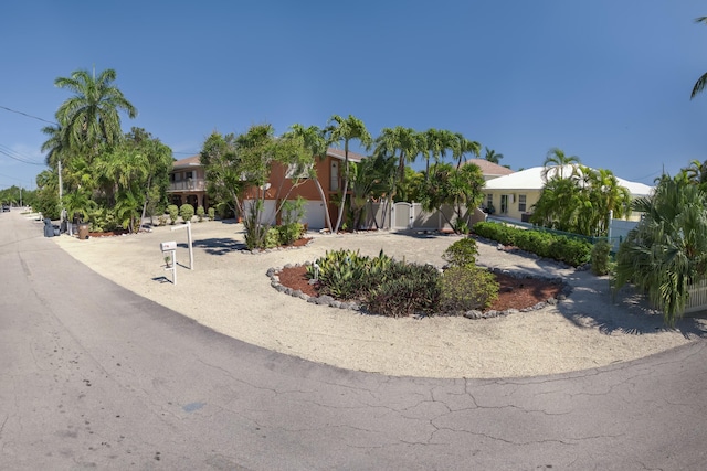 view of property hidden behind natural elements featuring fence