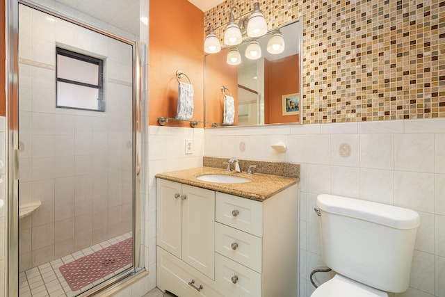 bathroom with toilet, a stall shower, vanity, and tile walls