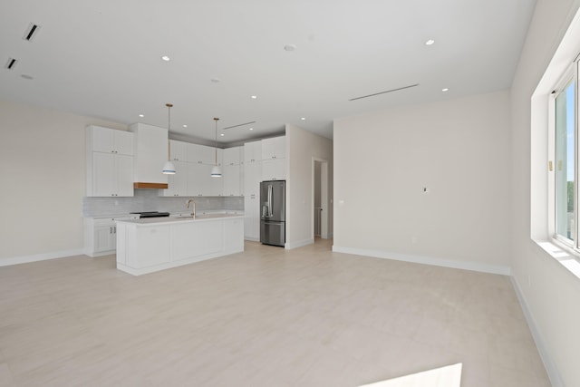 kitchen with white cabinetry, a center island with sink, hanging light fixtures, and stainless steel fridge with ice dispenser