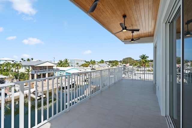 balcony with ceiling fan and a water view