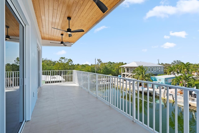 balcony with ceiling fan and a water view