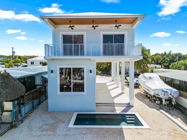 back of property featuring a balcony, ceiling fan, and a patio area