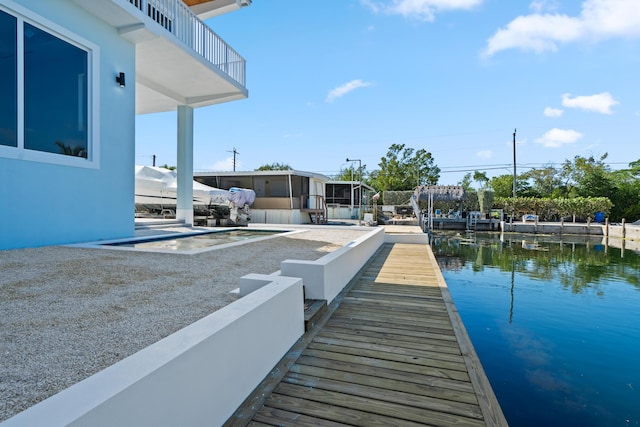 view of dock with a water view and a patio area