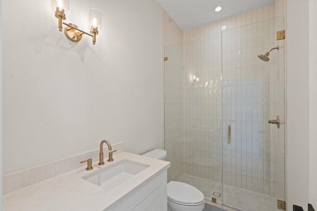 bathroom with vanity, toilet, and a shower with door