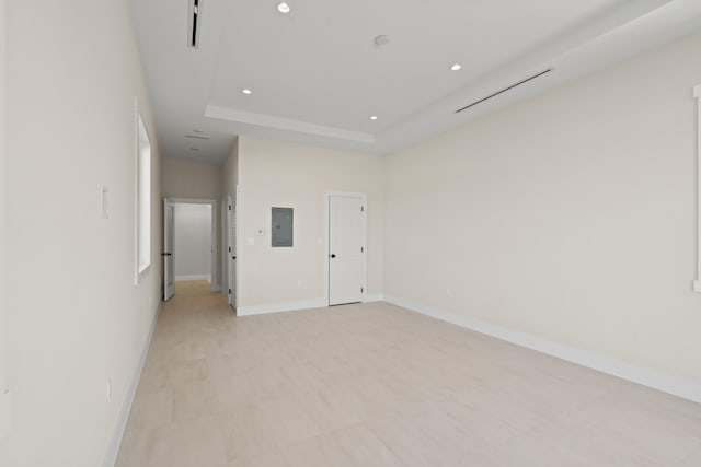 empty room featuring a tray ceiling and electric panel