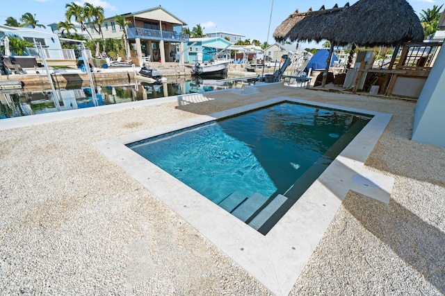 view of swimming pool with a water view and a patio area