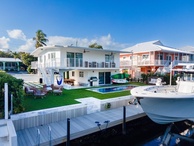 rear view of property with a patio, a water view, and a yard