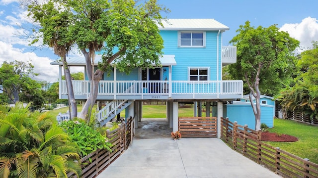 25057 7th St, Summerland, FL 33042 - view of front of home featuring a carport, a porch, driveway, stairway, and metal roof