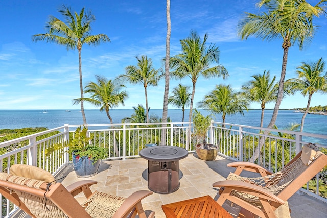 view of patio featuring a water view and a balcony