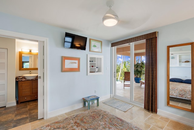 entryway with stone finish flooring, a sink, and baseboards