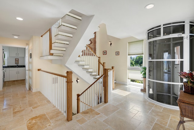 interior space featuring stairway, baseboards, stone tile flooring, and recessed lighting