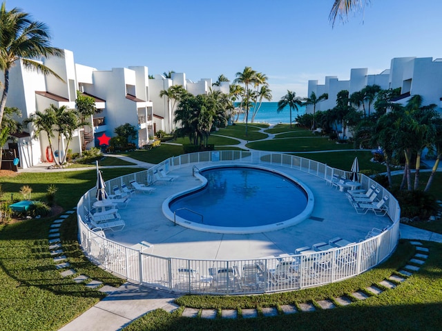 view of swimming pool featuring a water view and fence