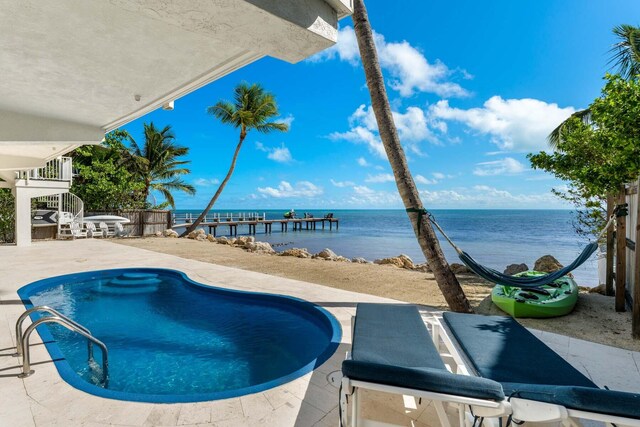 view of pool with a water view and a patio area