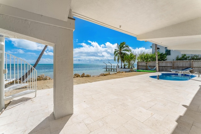 view of swimming pool with a water view and a patio