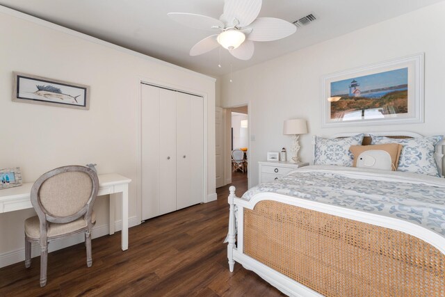 bedroom with dark wood-type flooring, ceiling fan, and a closet