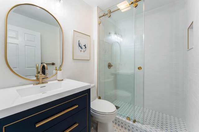 bathroom with vanity, a shower with shower door, and toilet