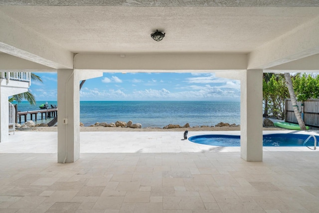 view of pool with a patio area and a water view