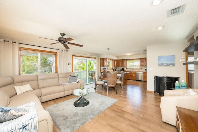 22738 Blackbeard Ln, Cudjoe, FL 33042 - living room featuring plenty of natural light, ceiling fan, a textured ceiling, and light wood finished floors